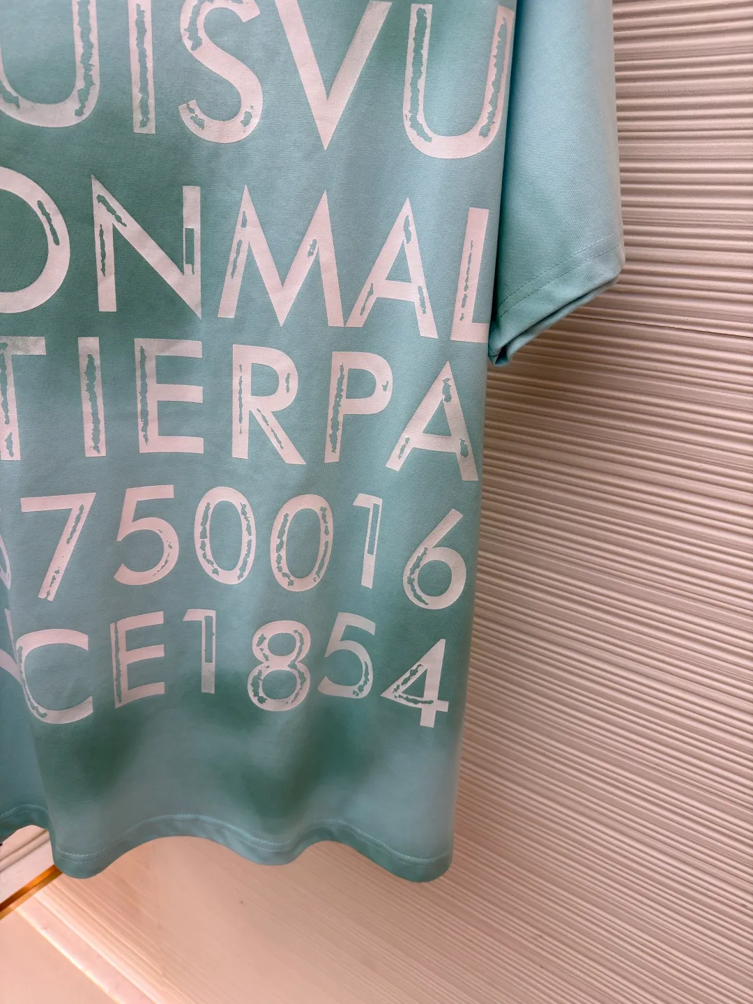 LOUIS VUITTON tie-dye printed cotton T-shirt ●Original version: Purchased and developed for 8500 ●Item number: 1682282-A15 ●Fabric: cotton fabric ●Technology: tie-dye printing production ●Color: blue ●Version: fitted version ●Weight: about 300 grams ●Size: S-M-L-XL ●Description: This Louis Vuitton letter-printed short-sleeved T-shirt is made of high-count combed cotton fabric. It has been treated with pre-washing water to achieve a soft and skin-friendly touch while avoiding shrinkage and deformation after wearing. The body of the shirt has a fresh mint green tone. The color is dyed through an environmentally friendly reactive dyeing process. It has high color fastness and is not easy to fade after being washed for a long time. The front letter printing uses imported glue screen printing technology and is completed in multiple overprints. The edges of the fonts are clear and textured, forming a natural concave and convex contrast with the fabric. The body is cut into a loose off-shoulder version, and the shoulder seams are embedded with a clipping process. The lines are smooth and have no irritation on the skin. The neckline is equipped with a double-needle ribbed hemming design, which is durable and not easy to loosen. Every stitch strictly follows the brand's craftsmanship standards. The details highlight the rigor and sophistication of luxury product production. The brand's classic logo and modern craftsmanship are integrated to create a ready-to-wear effect with both texture and design. The overall wiring is straight and delicate, the fabric is comfortable and soft, and the color is consistent without color difference. It can be matched with the same style to create a fashionable look and control various occasions. Customized accessories, complete with three standards, same style for men and women!
